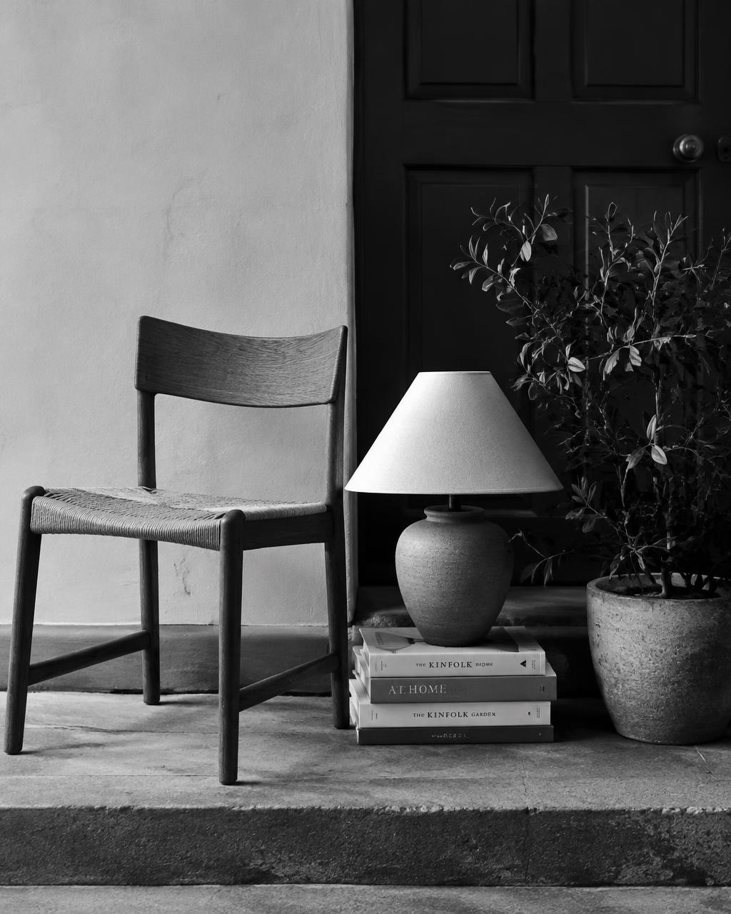 A chair, lamp, books and plant left on a doorstep
